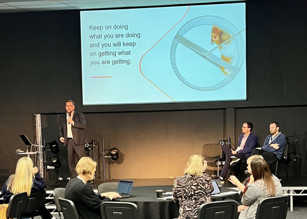 Dan presenting at LGComms Academy with presentation behind saying 